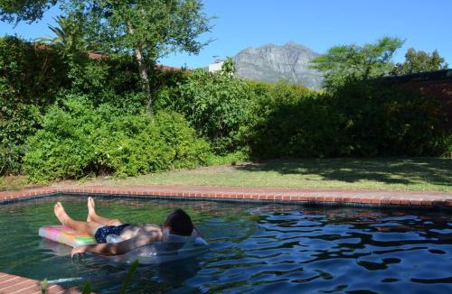 Die Boord House | Retro Red Stone Villa with pool & lush garden